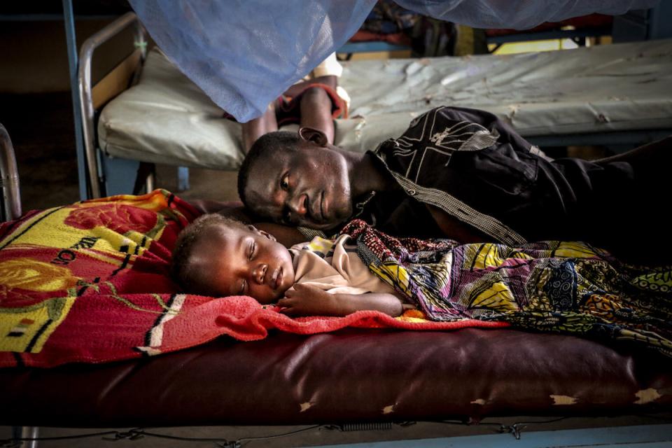 On 19 July 2018 in the Central African Republic, Pierre Mbassissi and his father in bed at the malnutrition stabilisation centre at the Bangui Paediatric hospital.