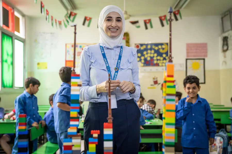 Sajeda, a UNICEF Jordan Early Childhood Development Specialist, plays with children at a Makani center in 2018. Sajeda, a UNICEF Jordan Early Childhood Development Specialist, plays with children at a Makani center in 2018.