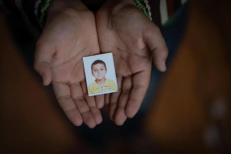 Yahya, 13, holds a passport photo of himself in northern Jordan's Zaatari refugee camp in 2018. Yahya was in the first grade for one week before his family fled Syria. He keeps the photo to remember his childhood. UNICEF, Syria, Syrian refugees, Jordan, Zaatari