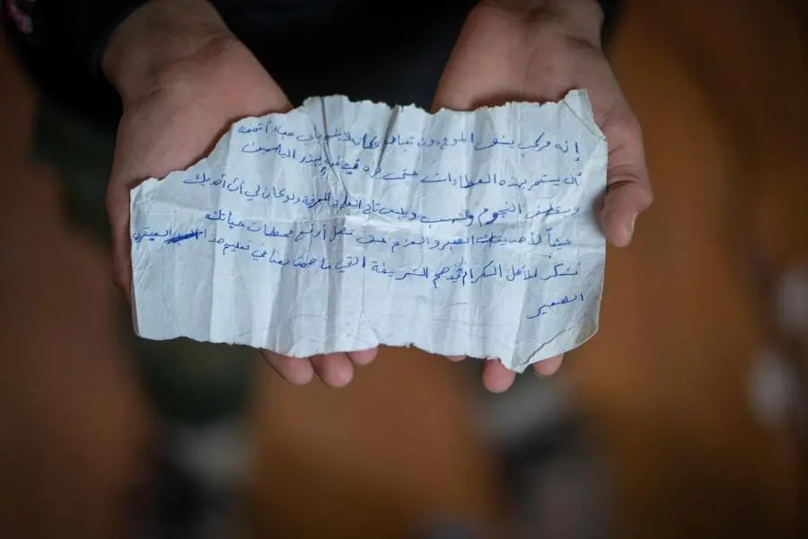 In Jordan's Zaatari refugee camp, Hamza, 14, holds a handwritten note from his teacher in Syria in 2018. The note calls Hamza a star. He treasures it. UNICEF, Syria, refugees, Syrian refugees