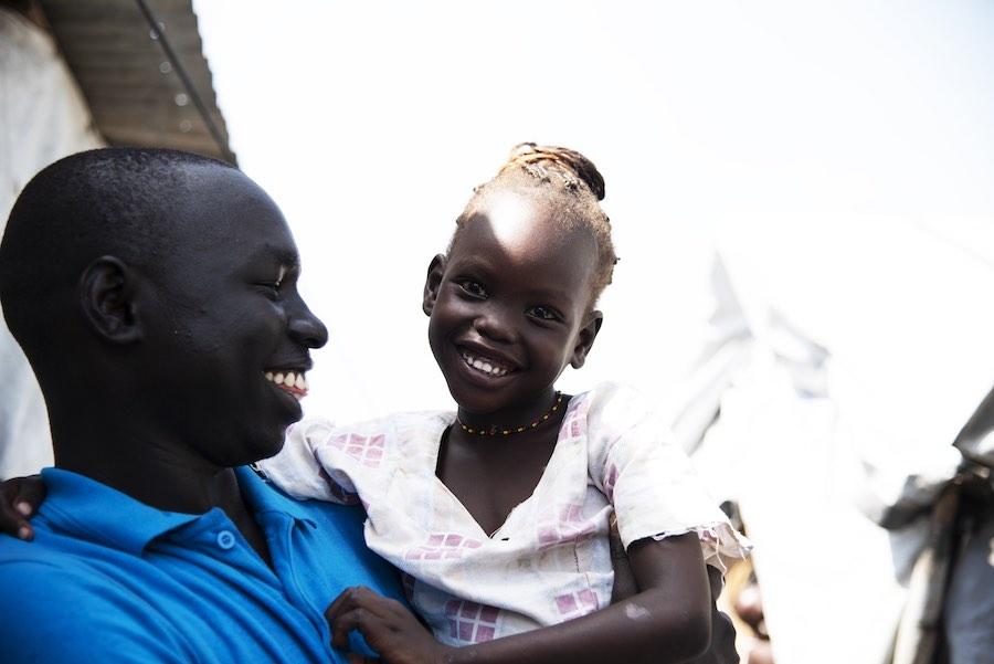 Simon Char with five-year-old Nyajiper Iwany in his arms. She has been separated from her parents for more than four years. Recently her father was found in Bor and Nyajiper will be reunited with him in just a few weeks. “I’ve told her that she will soon 