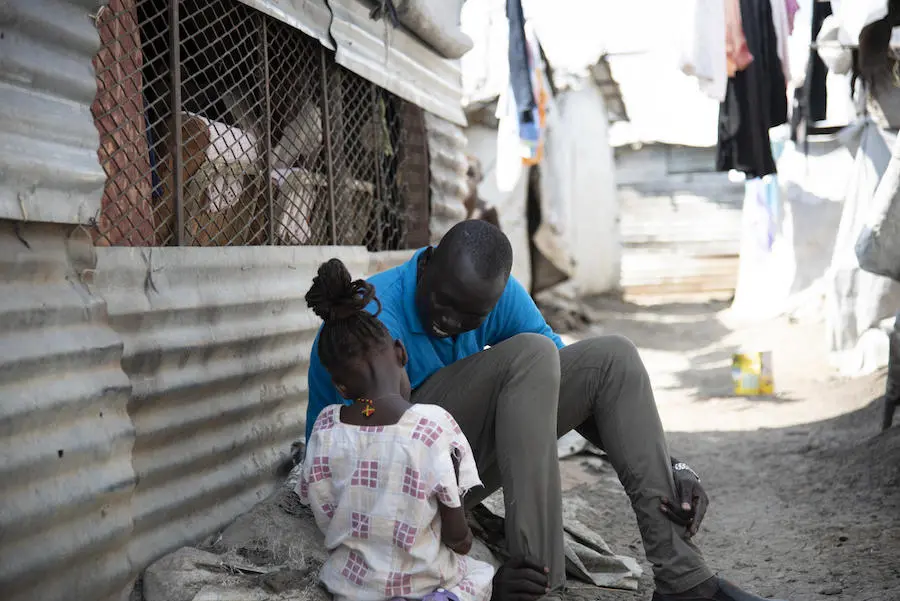 Simon Char works toward family reunification. Simon Char, a UNICEF caseworker, plays with 5-year-old Nyajiper. UNICEF recently found Nyajiper’s father, and the two will be reunited soon.