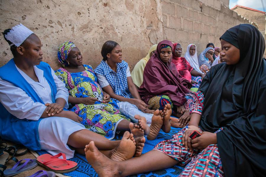 Amilia Mathew (center, in her checked uniform) advises pregnant women and mothers on health issues during a community outreach activity in Yola, Nigeria in November 2018.