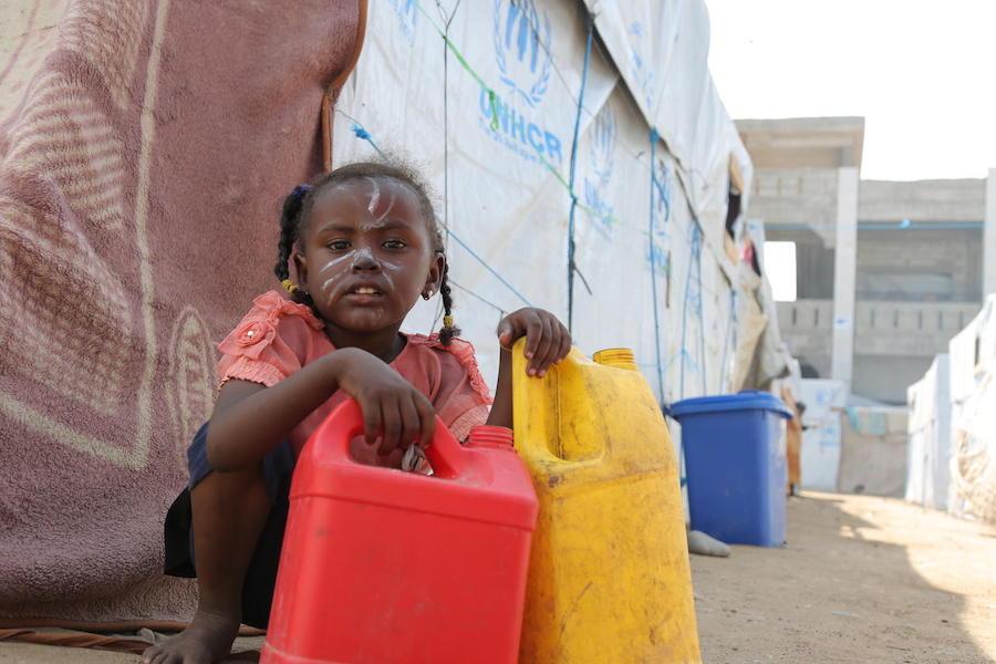 A girl holds containers used for carrying water at a camp for internally displaced persons in Aden, Yemen on December 4, 2018.