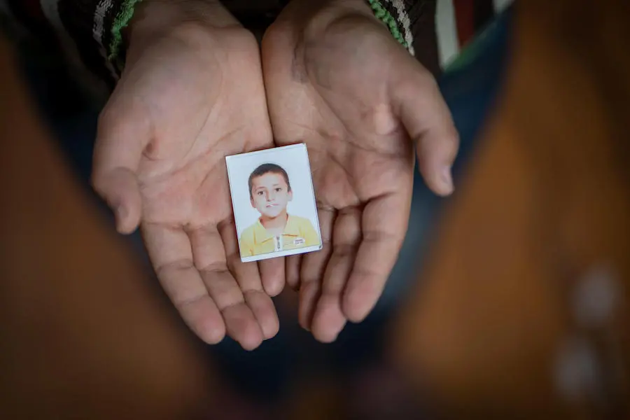 Yahya, 13, holds an old passport photo of himself in Za'atari refugee camp. Yahya, 13, holds an old passport photo of himself in Za'atari refugee camp.