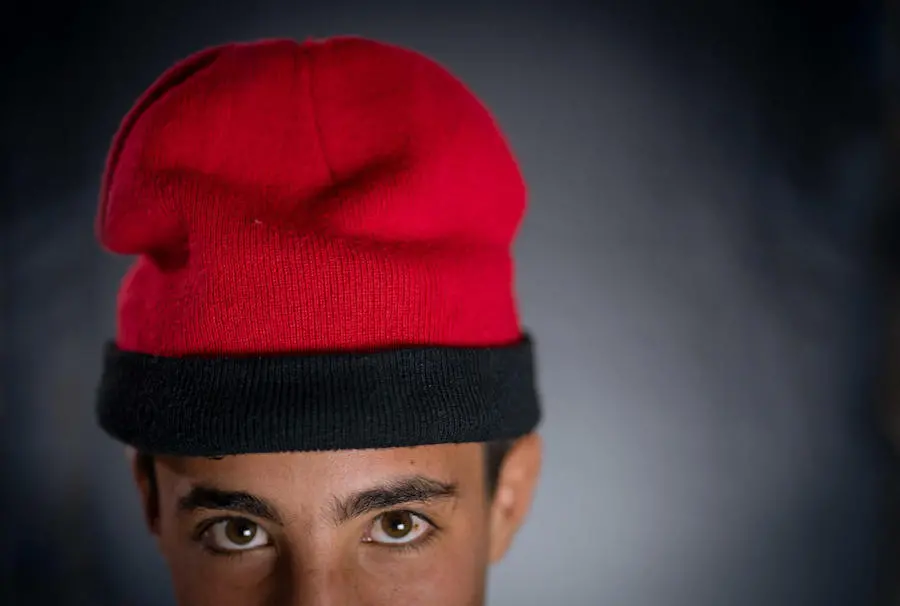 Mohammad, 16 years, wears his hat from Syria in Za’atari Refugee Camp. Mohammad, 16 years, wears his hat from Syria in Za’atari Refugee Camp.