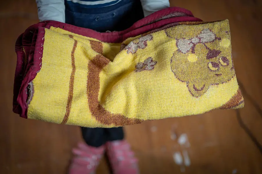 In Jordan's Za'atari Refugee Camp, Nour, 12, holds a blanket she brought from home in Syria. In Jordan's Za'atari Refugee Camp, Nour, 12, holds a blanket she brought from home in Syria.