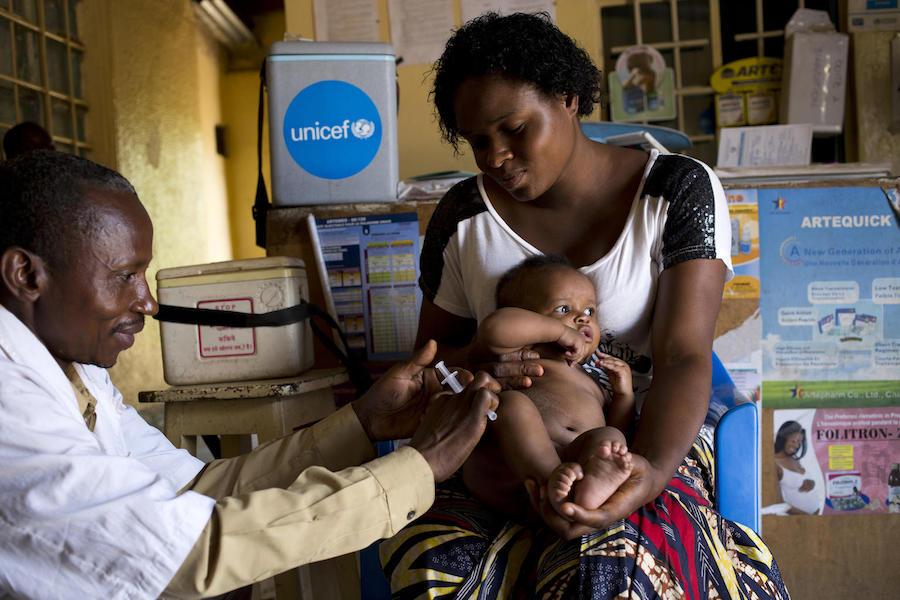 UNICEF-supported health worker Nsiri Lowoso vaccinates Zoe, 3 months, with the MMR (measles, mumps and rubella) vaccine as his mom, Arellete Ytshika, holds him in Lubumbashi, Democratic Republic of Congo on November 10, 2018.