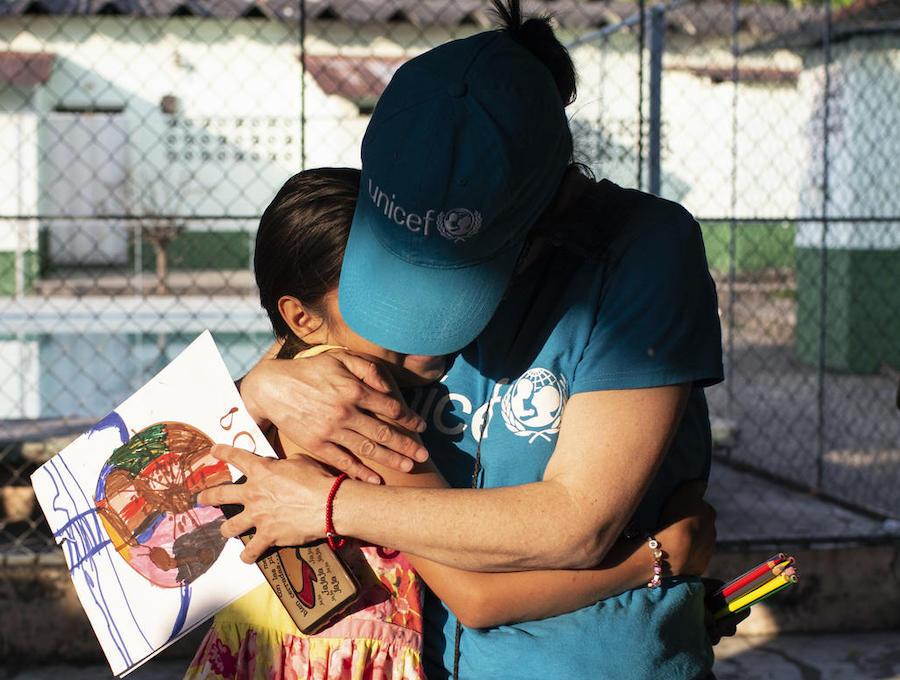 Jennifer, 10, who fled Honduras with her three siblings after their mother was killed by a gang, hugs a UNICEF volunteer at a hotel for asylum seekers in Tapachula, Mexico. 