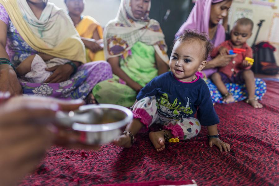 Rimpi Rani, an Aanganwadi worker feeds a child during a meeting as part of Village Health and Nutrition Day (VHND) in Motipur Kala Aanganwadi Centre in Shrawasti, Uttar Pradesh.