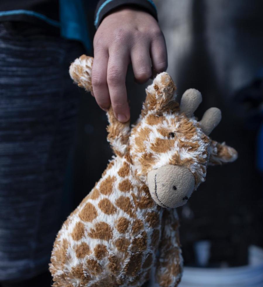 At a shelter for unaccompanied migrant adolescents in Tijuana, Mexico in February 2019, Maylin, 15, holds the toy giraffe she carries with her on the caravan.