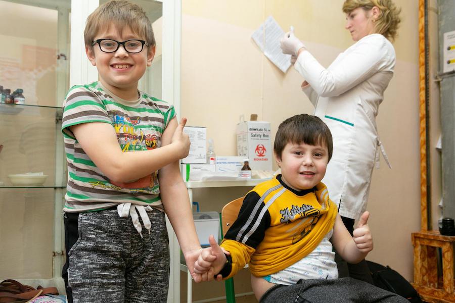 Liubomyr, 8, and his brother Bohdan, 6, held hands while Bohdan received his measles, mumps and rubella vaccination in western Ukraine's Lviv region in February 2019. 