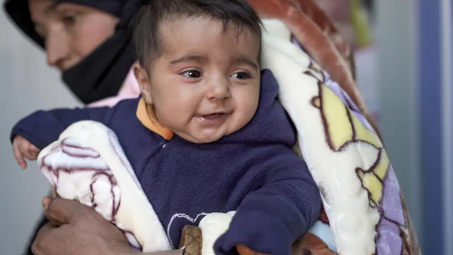In Jordan, 3-month-old Hala wears a fleece jumpsuit sewn by Syrian refugees in a UNICEF-backed sewing workshop in Za'atari Refugee Camp. In Jordan, 3-month-old Hala wears a fleece jumpsuit sewn by Syrian refugees in a UNICEF-backed sewing workshop in Za'atari Refugee Camp.