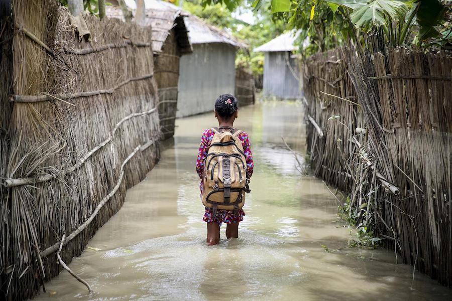 A child wades through water on her way to school in Kurigram district in northern Bangladesh during floods in August 2016.