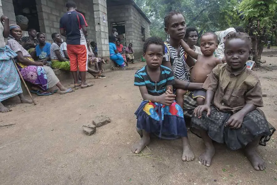 Mary Staford and her three daughters sit with and other people displaced by the floods at a camp set up at the Nyachilenda School in Nsanje. The 75,900 people displaced in Malawi are spread out over 187 camps, most of which are located in schools. © UNIC Mary Staford and her three daughters sit with and other people displaced by the floods at a camp set up at the Nyachilenda School in Nsanje. The 75,900 people displaced in Malawi are spread out over 187 camps, most of which are located in schools. © UNIC