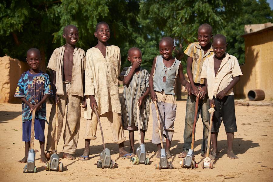 Boys stand with homemade toys in the village of Kadazaki, Matameye department, Niger on August 14, 2016.