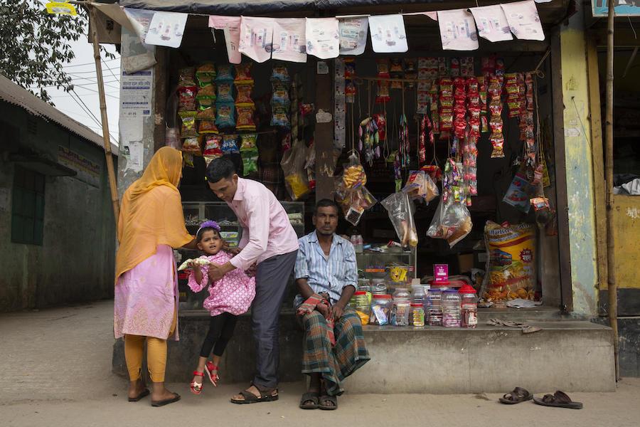 Jamal Hossain, 26, his wife, Shumi Akhter, 20, and their 2 1/2-year-old daugher, Jui, shop for treats near their home in Gazipur outside Dhaka, Bangladesh on December 6, 2018.