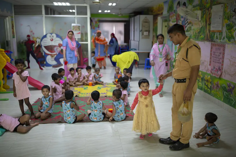 Jisha, 3, holds the hand of her father, Mohammad Jahirul Islam, 28, before he leaves her at the day care centre she attends at Fakir Fashion Ltd. factory, where he works as a firefighter, Narayangonj, outside Dhaka, Bangladesh on December 10, 2018. Jisha, 3, holds the hand of her father, Mohammad Jahirul Islam, 28, before he leaves her at the day care centre she attends at Fakir Fashion Ltd. factory, where he works as a firefighter, Narayangonj, outside Dhaka, Bangladesh on December 10, 2018.
