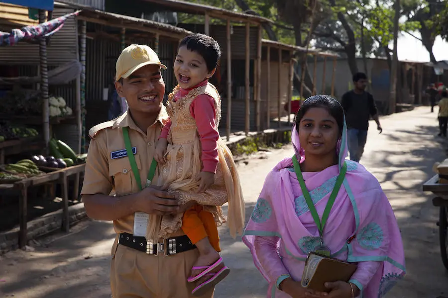 Dressed in his firefighter uniform, Mohammad Jahirul Islam carries his daughter, Jisha, 3, to the UNICEF-supportedday care center she attends at the garment factory where he and his wife work in Narayangonj, outside Dhaka, Bangladesh on December 10,2018. Dressed in his firefighter uniform, Mohammad Jahirul Islam carries his daughter, Jisha, 3, to the UNICEF-supportedday care center she attends at the garment factory where he and his wife work in Narayangonj, outside Dhaka, Bangladesh on December 10,2018.