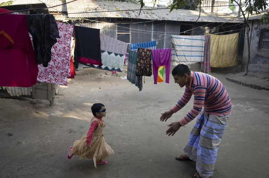 After he comes home from work, Mohammad Jahirul Islam, 28, plays with his daughter, Jisha, 3, in the courtyard outside their home in Narayangonj, outside Dhaka, Bangladesh on December 10, 2018 After he comes home from work, Mohammad Jahirul Islam, 28, plays with his daughter, Jisha, 3, in the courtyard outside their home in Narayangonj, outside Dhaka, Bangladesh on December 10, 2018
