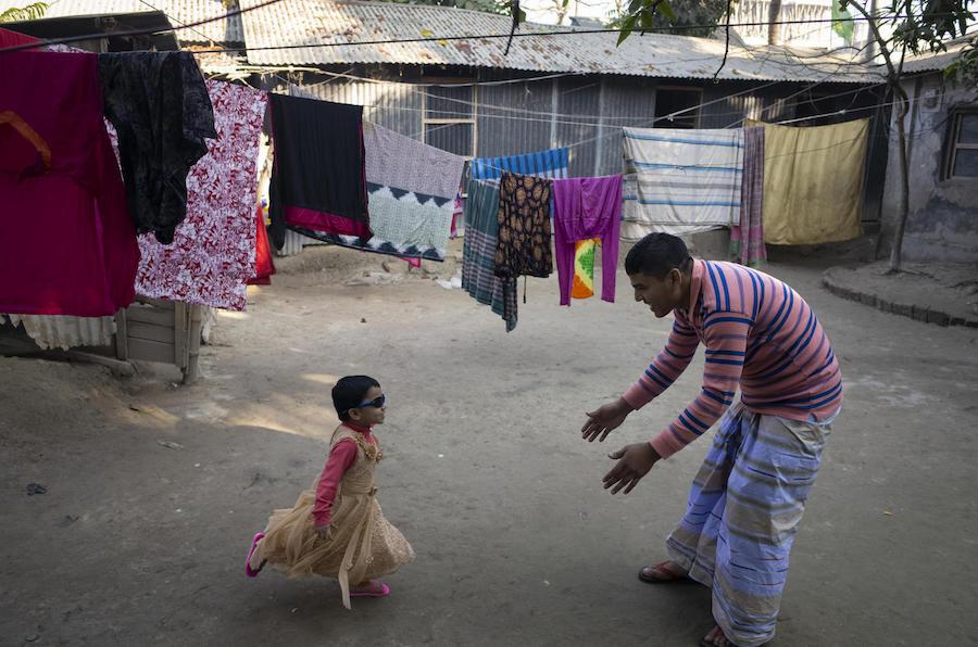 After he comes home from work, Mohammad Jahirul Islam, 28, plays with his daughter, Jisha, 3, in the courtyard outside their home in Narayangonj, outside Dhaka, Bangladesh on December 10, 2018