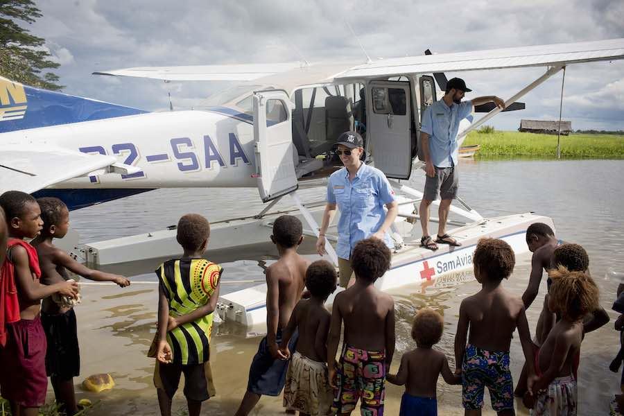 Tracy Hamer, a pilot with Samaritan Aviation meets local children in Angoram, East Sepik Province, Papua New Guinea. Tracy has a five-month-old baby but regularly flies into remote regions of East Sepik Province, delivering essential vaccinations and medi
