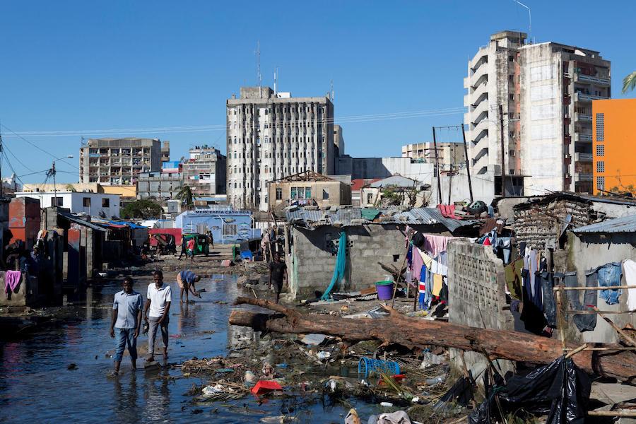 On March 24, 2019 in Beira, Mozambique, people walk in an area that was flooded after Cyclone Idai made landfall. 