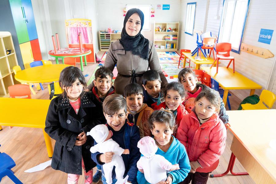 Syrian refugee children and their teacher in a UNICEF-built and -equipped kindergarten in Jordan's Za'atari Refugee Camp in March 2019.