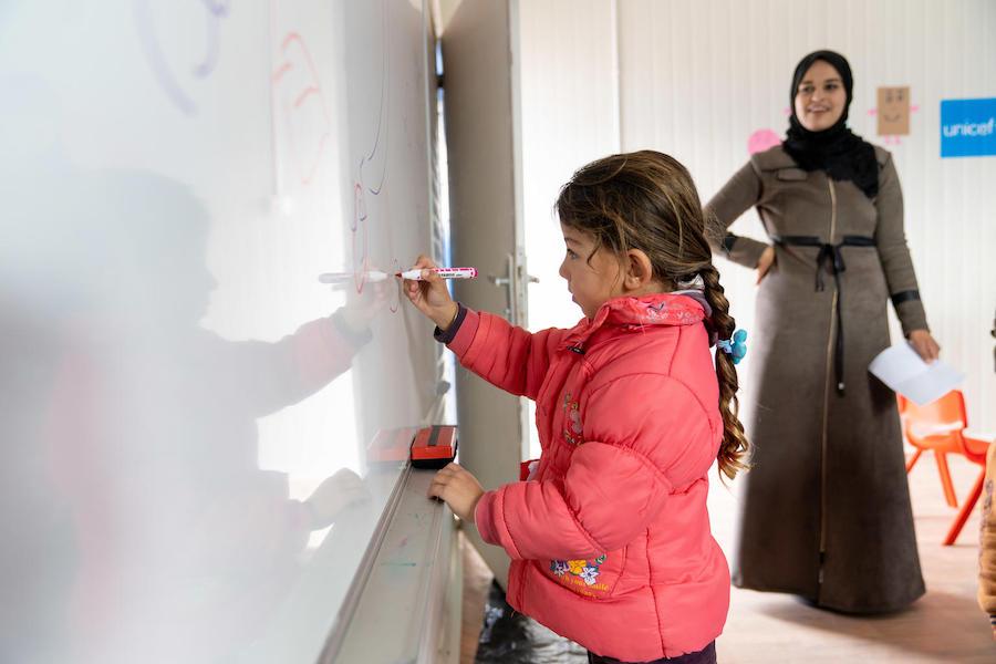 Maya, 6, practices writing letters and numbers in her new kindergarten classroom, built and equipped by UNICEF at Za'atari Refugee Camp in Jordan in 2019.