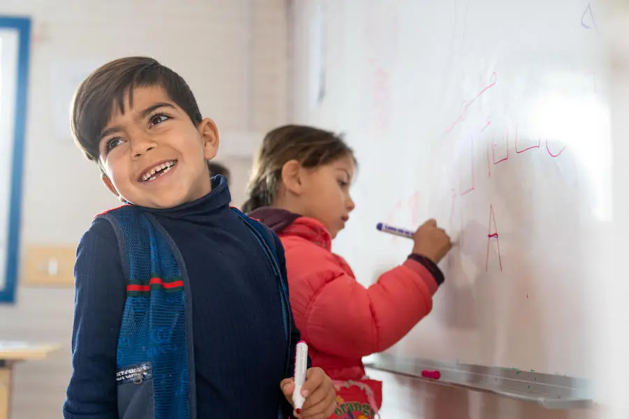 Mohammad and classmates are learning letters and numbers in their UNICEF-supported kindergarten class at Za'atari Refugee Camp in Jordan in 2019. Mohammad and classmates are learning letters and numbers in their UNICEF-supported kindergarten class at Za'atari Refugee Camp in Jordan in 2019.