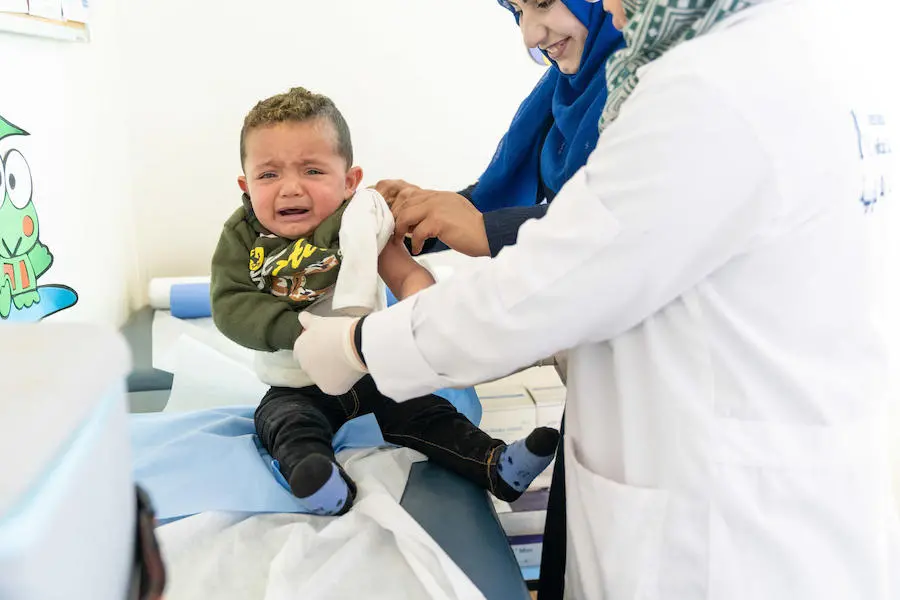 In Jordan's Azraq refugee camp in 2019, 1-year-old Mohammad receives his masles, mumps and rubella vaccination from UNICEF-supported health workers. In Jordan's Azraq refugee camp in 2019, 1-year-old Mohammad receives his masles, mumps and rubella vaccination from UNICEF-supported health workers.