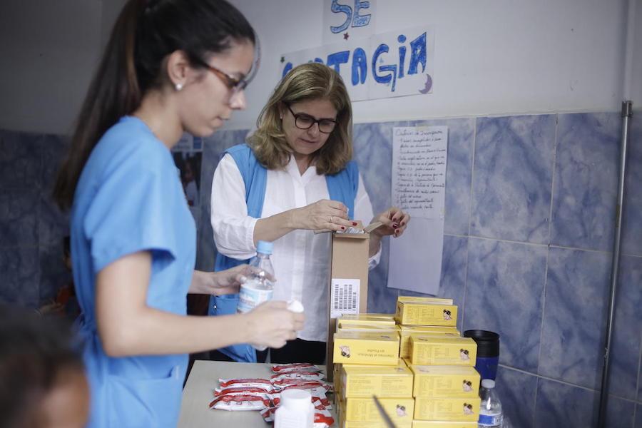 In June 2019, at a school in Petare on the outskirts of Caracas, Venezuela, UNICEF Director of Communication Paloma Escudero and a health worker unpack Plumpy Nut Ready-to-Use Therapeutic Food for distribution to children suffering from malnutrition. 