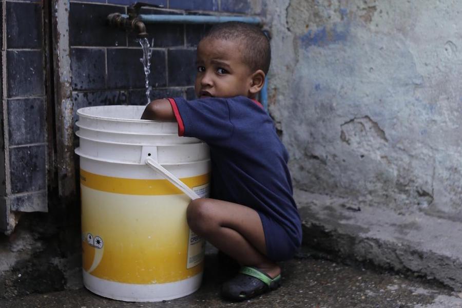 In June 2019, a child collects water in Petare, one of the most vulnerable neighborhoods in Caracas, Venezuela. UNICEF provided safe drinking water to 400,000 people in Venezuela in the first half of 2019.
