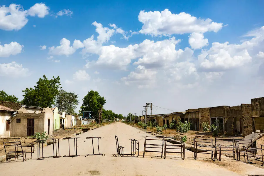 A row of old desks lie across the road on the outskirts of Banki town in northeast Nigeria in May 2019. Homes, shops and schools are deserted due to insecurity in the region. A row of old desks lie across the road on the outskirts of Banki town in northeast Nigeria in May 2019. Homes, shops and schools are deserted due to insecurity in the region.