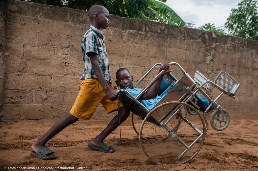 A friend pushes Ilídio, 11, in his wheelchair so he doesn't have to stay home in Mozambique in July, 2019. A friend pushes Ilídio, 11, in his wheelchair so he doesn't have to stay home in Mozambique in July, 2019.