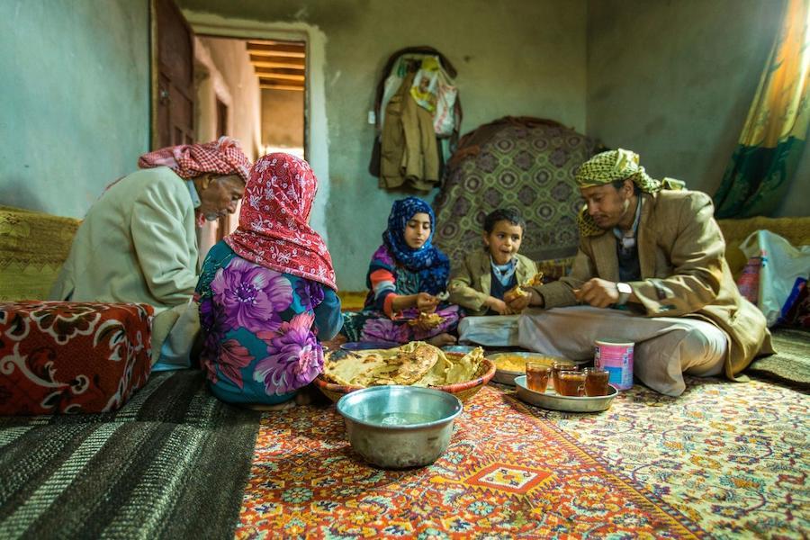 A family from Amran Governate in Yemen shares lunch on July 12, 2019. The family used money received through the Emergency Cash Transfer project to purchase food. 