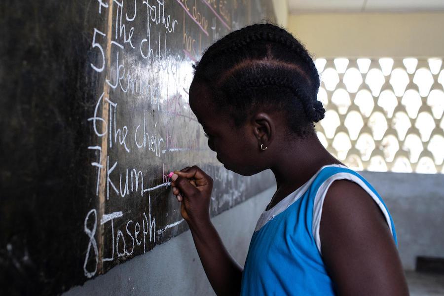 A student works on her spelling at the blackboard in class at GEPS Youpwe, a UNICEF-supported government primary school in Douala, Cameroon on May 21, 2019. 
