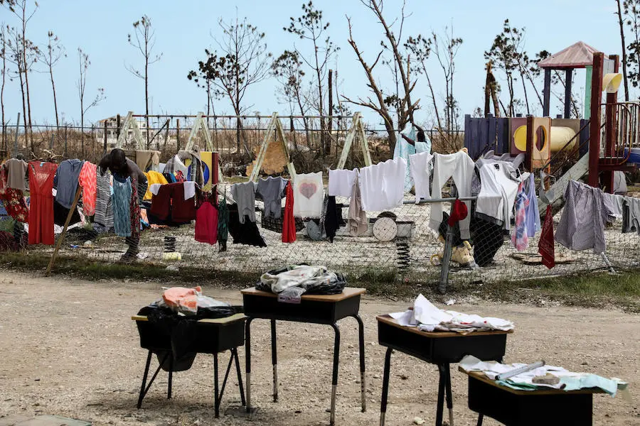 On September 7, 2019, a man hangs clothes in the playground at Central Abaco Primary School in Marsh Harbour, Abaco Island, Bahamas. On September 7, 2019, a man hangs clothes in the playground at Central Abaco Primary School in Marsh Harbour, Abaco Island, Bahamas.