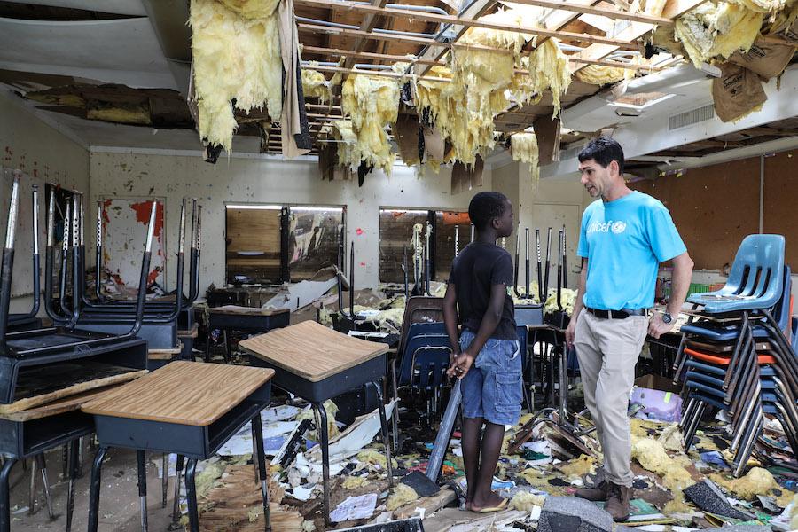 Torres, 10, with UNICEF’s Regional Emergency Specialist Hanoch Barlevi, in a classroom destroyed by Hurricane Dorian.