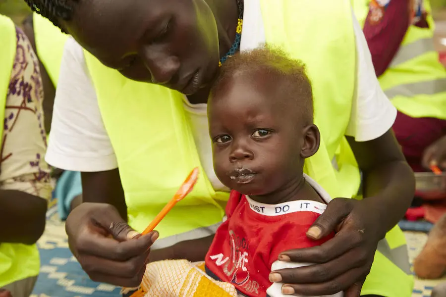 Wel Wel, 13 months, is fed porridge by his mother, Skechers Piol, at a UNICEF-supported mother-to-mother support group in Aweil, South Sudan, on September 5, 2019. Wel Wel, 13 months, is fed porridge by his mother, Skechers Piol, at a UNICEF-supported mother-to-mother support group in Aweil, South Sudan, on September 5, 2019.