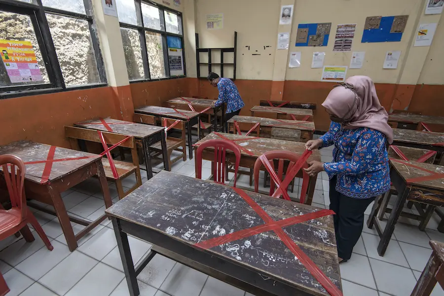 Teachers at SDN Sukamaju primary school in Bandung, West Java province, Indonesia, mark classroom desks and chairs to ensure that students keep 6 ft. apart from each other to prevent the spread of coronavirus. Teachers at SDN Sukamaju primary school in Bandung, West Java province, Indonesia, mark classroom desks and chairs to ensure that students keep 6 ft. apart from each other to prevent the spread of coronavirus.