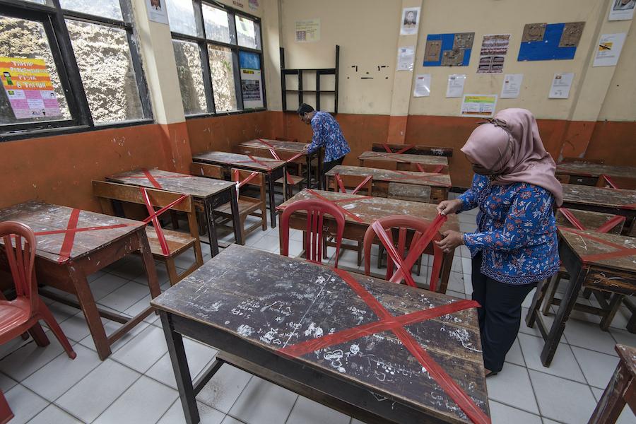 Teachers at SDN Sukamaju primary school in Bandung, West Java province, Indonesia, mark classroom desks and chairs to ensure that students keep 6 ft. apart from each other to prevent the spread of coronavirus.