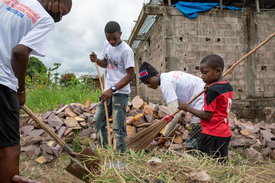 A group of young children from Kinshasa, Democratic Republic of the Congo, pause their clean-up activities to take a photo. The group, who range in age from 4 to 18, meet every Saturday morning to remove waste and discarded debris from their neighborhoods