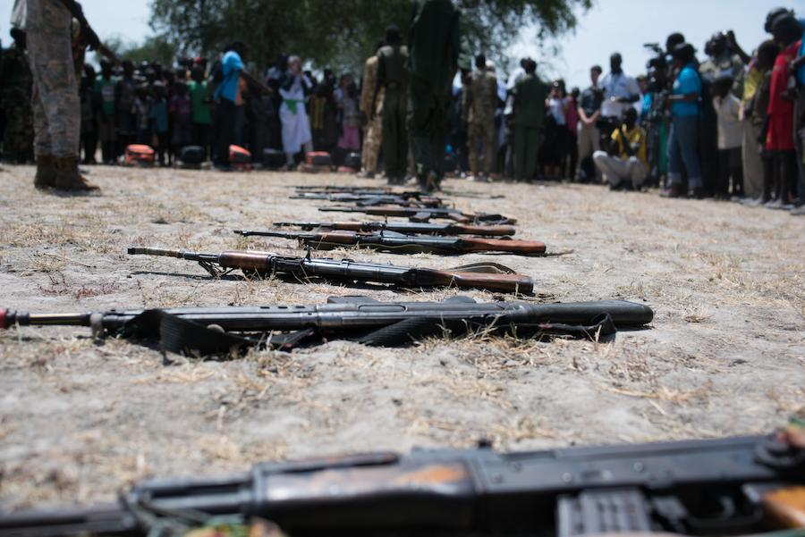 Children associated with the Cobra faction wait to be demobilized in Pibor, their weapons are seen on the ground. A total of 145 children from the Cobra Faction and SPLA-IO were disarmed and released by the two armed groups.