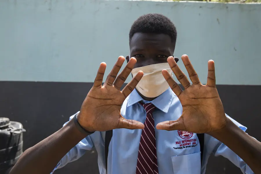 Daniel, 17, washed his hands with clean running water and soap before entering his classroom at Nile International Academy in Juba, South Sudan, in accordance with a new school rule. Daniel, 17, washed his hands with clean running water and soap before entering his classroom at Nile International Academy in Juba, South Sudan, in accordance with a new school rule.