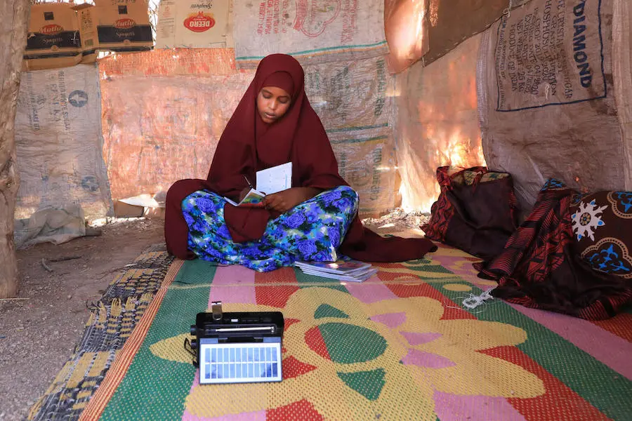 In Somalia, 14-year-old Farhia uses a small solar-powered radio provided by UNICEF and partners to listen to recorded lessons. In Somalia, 14-year-old Farhia uses a small solar-powered radio provided by UNICEF and partners to listen to recorded lessons.