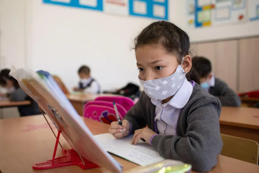 An 8-year-old student reads from her Russian language textbook at Kozhakeldy Batyr School in the remote village of Aksuat, in East Kazakhstan. In response to COVID-19, the school limited classroom access to pupils in Grades 1-4. An 8-year-old student reads from her Russian language textbook at Kozhakeldy Batyr School in the remote village of Aksuat, in East Kazakhstan. In response to COVID-19, the school limited classroom access to pupils in Grades 1-4.