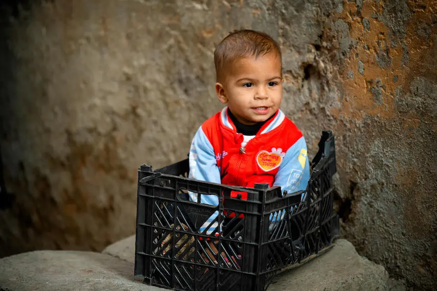 A two-year-old boy in Lahore, Pakistan, is amused by polio team immunizing children in his neighborhood as he waits to receive his own vaccination. A two-year-old boy in Lahore, Pakistan, is amused by polio team immunizing children in his neighborhood as he waits to receive his own vaccination.