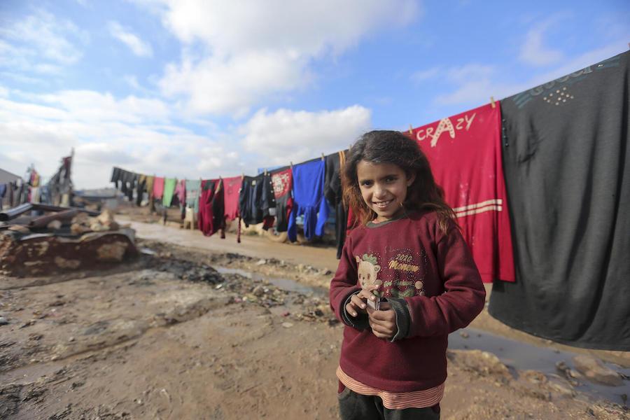 On 19 January 2021, a child stands in front of clothes hanging on a drying line in Kafr Losin Camp in northwest Syrian Arab Republic. 