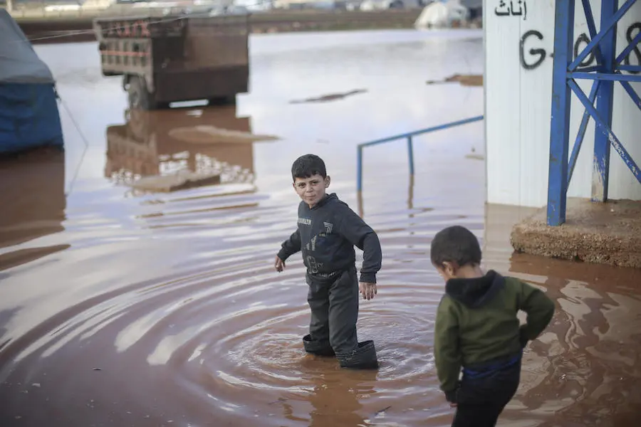 On 19 January 2021, children walk through a flooded area of Kafr Losin Camp in northwest Syrian Arab Republic. On 19 January 2021, children walk through a flooded area of Kafr Losin Camp in northwest Syrian Arab Republic.